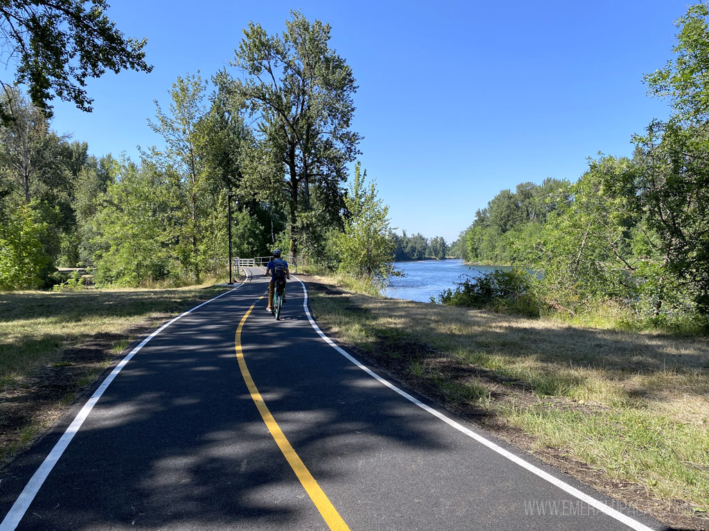 person biking on a paved trail in a park in Eugene