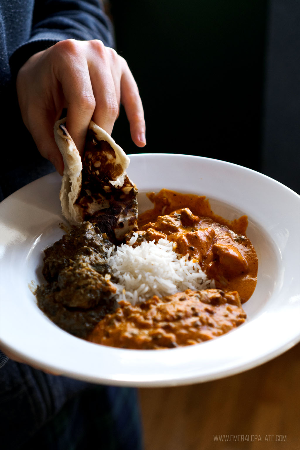 person dipping naan into Seattle Indian food