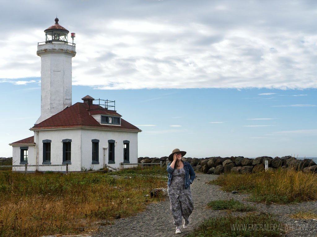 woman walking by a lighthouse in one of the most romantic getaways in the Pacific Northwest