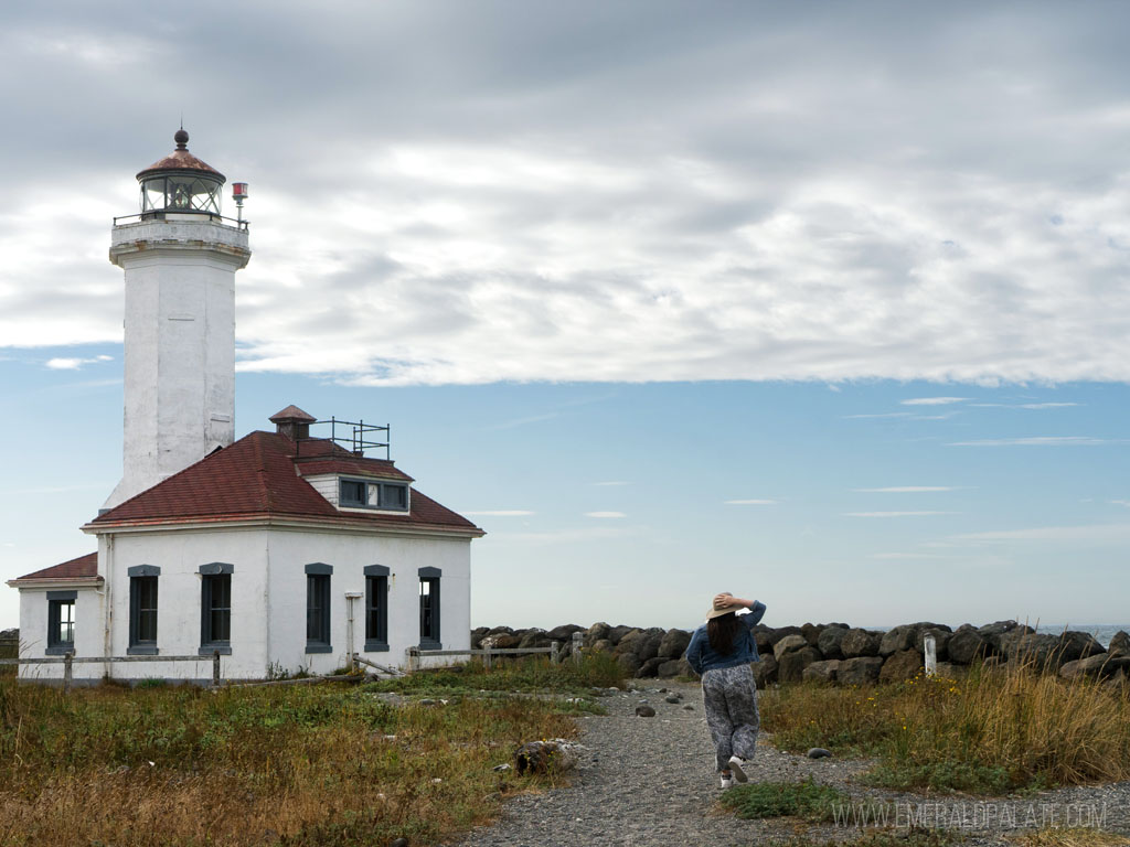 woman walking toward lighthouse, one of the best things to do in Port Townsend, WA