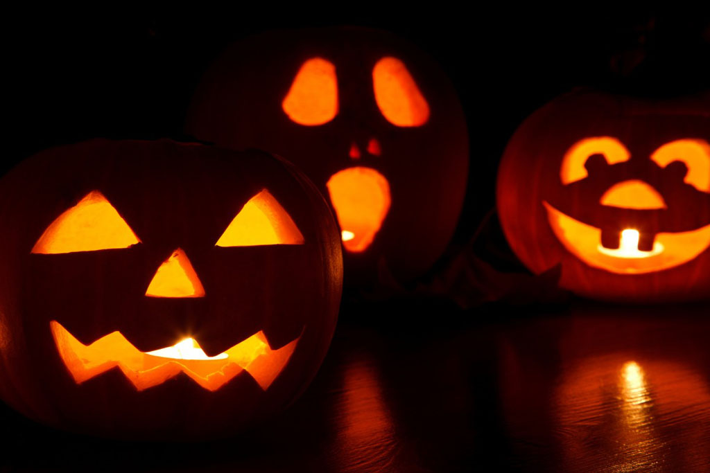3 Jack o' lanterns lit up at night, one of the best Halloween fun in Seattle