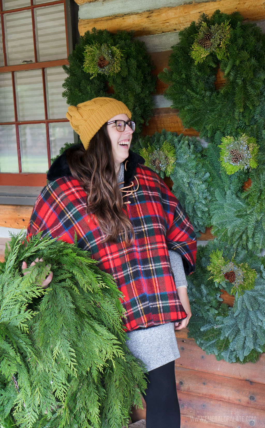 woman carrying garland and excited to shop at the best Seattle Christmas markets
