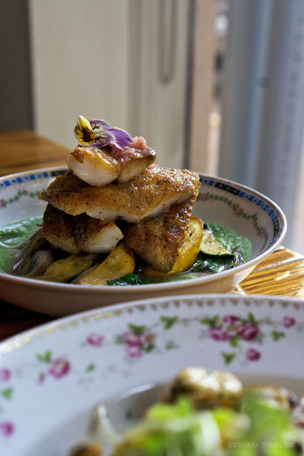 stacked fish dish with summer vegetables and a cucumber sauce