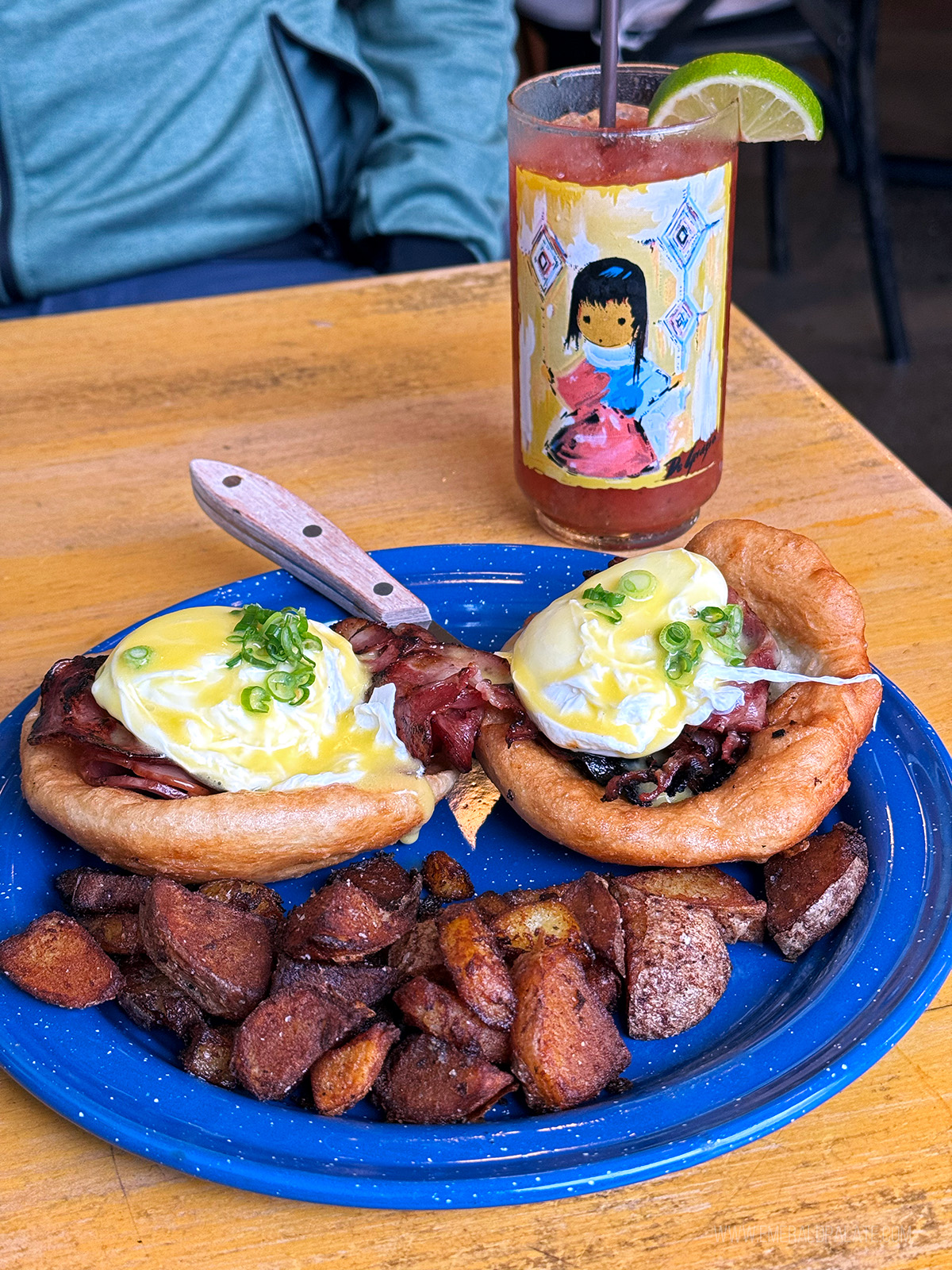 fry bread eggs Benedict with boar bacon and egg on top and a bloody Mary in back from one of Portland's only Indigenous restaurants