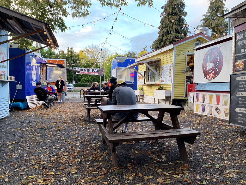 people sitting at a food cart pod, one of the most fun places to eat in Portland