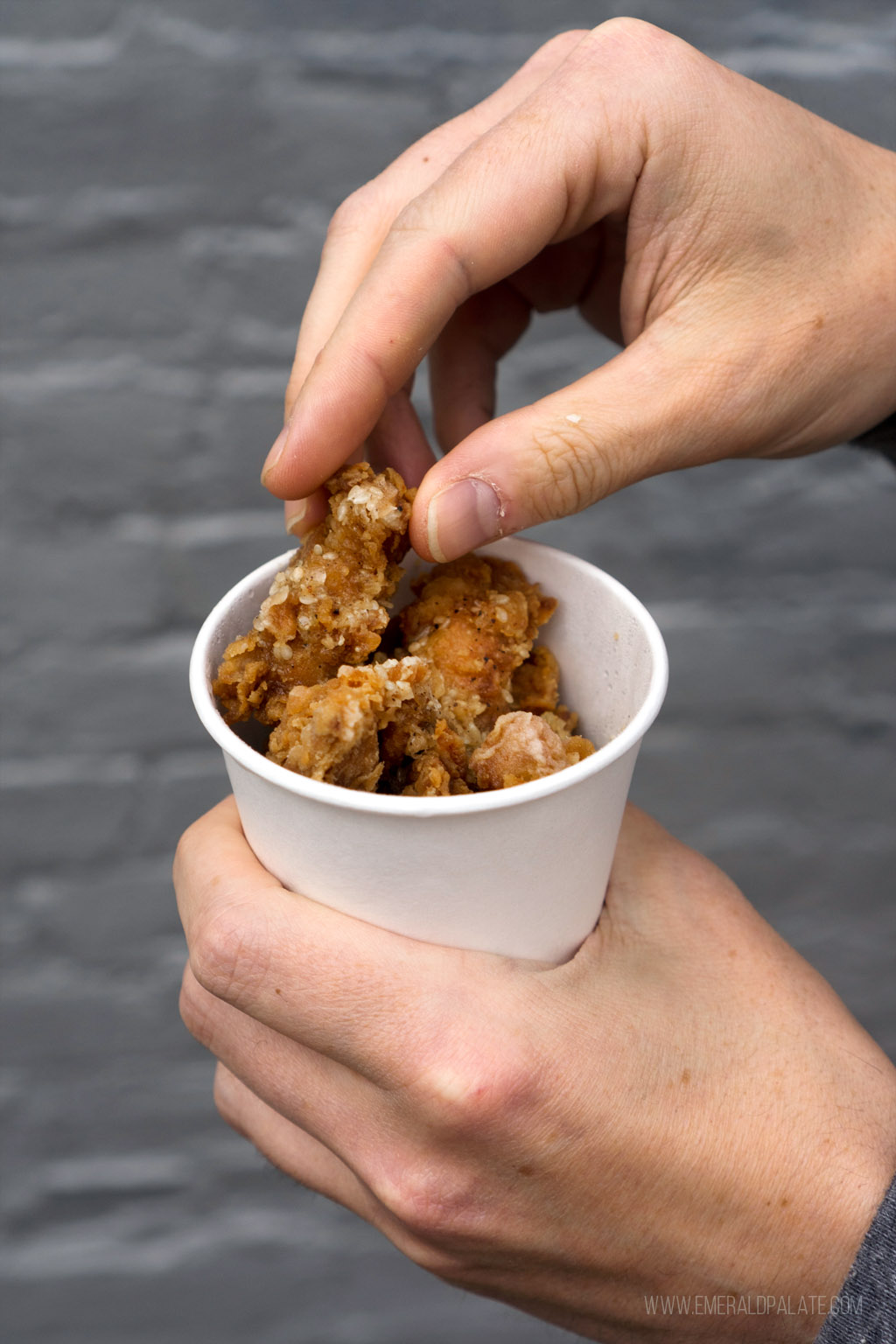 person picking up karaage from one of the most fun places to eat in Portland, Oregon