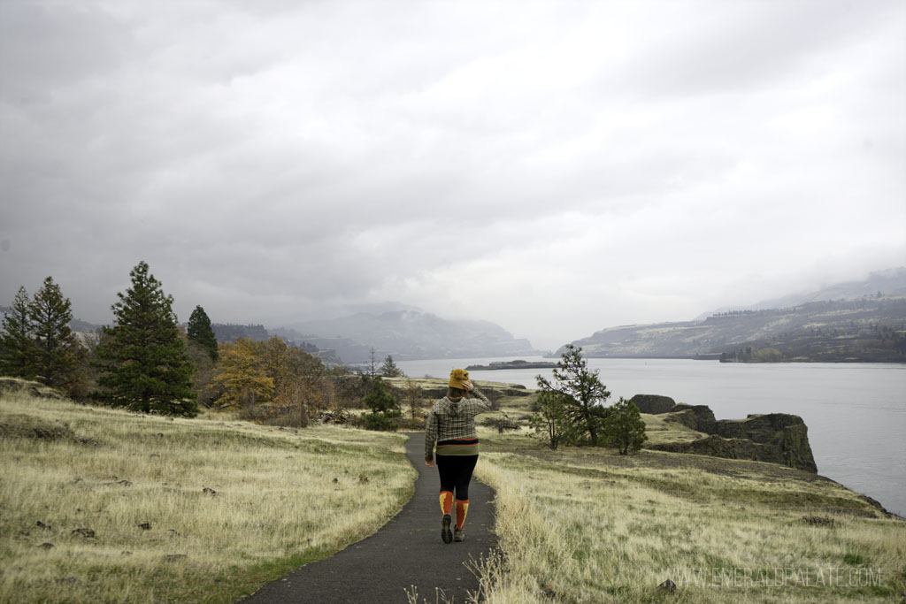 woman walking on a paved trail in a park overlook Columbia Gorge