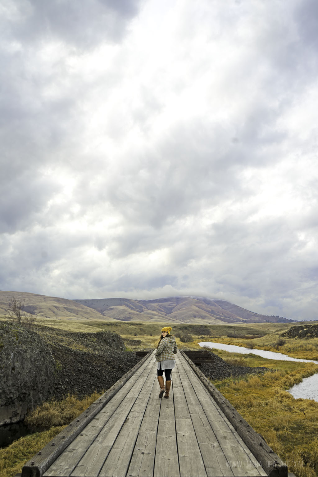 woman looking over her shoulder on a boardwalk while hiking in Columbia Gorge