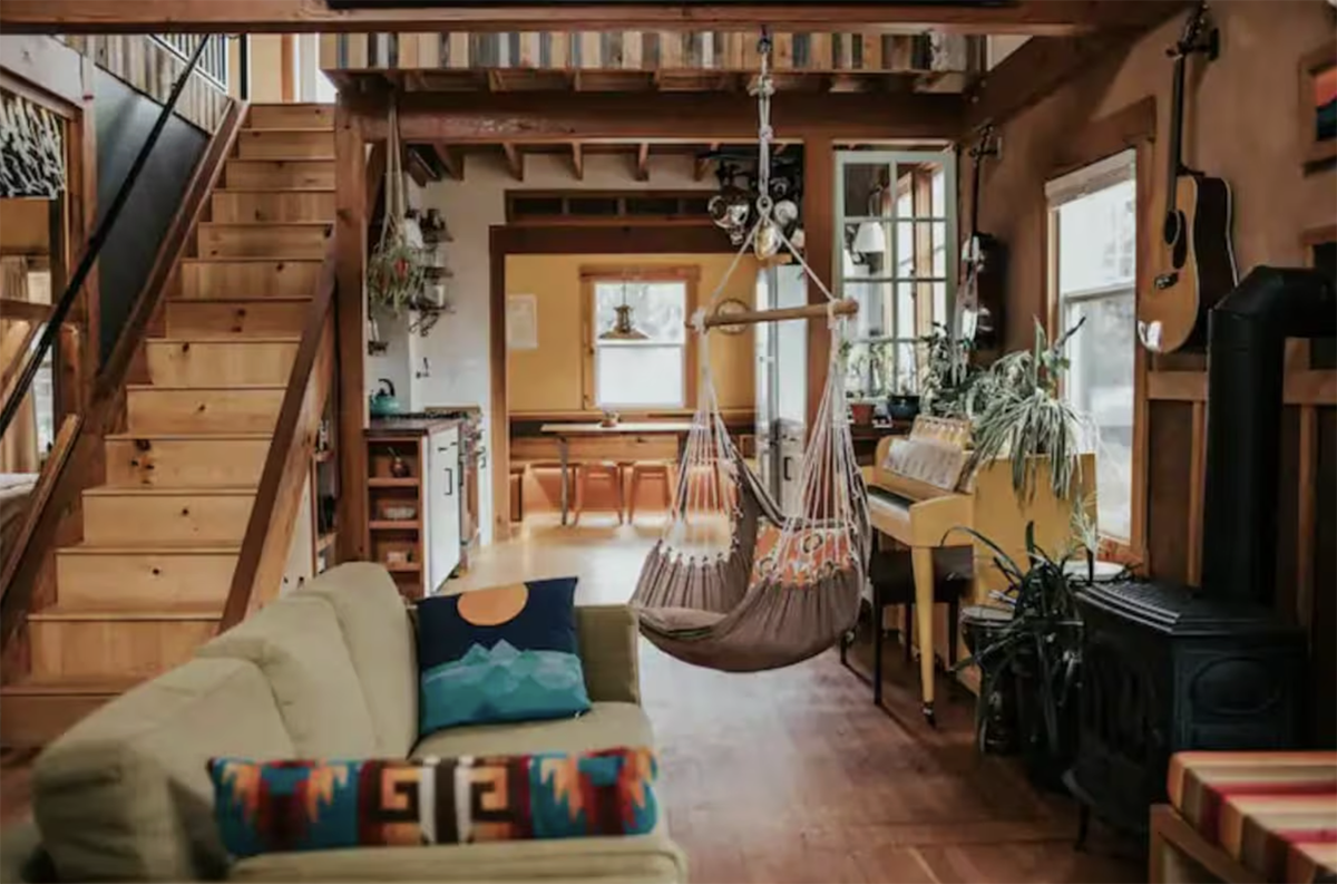 inside an artsy cabin with a hanging swing
