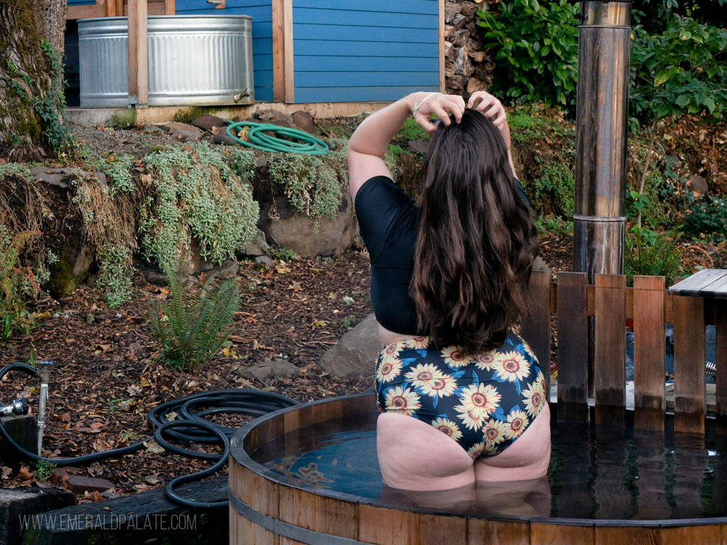 woman fixing hair in a hot tub at one of the best winter cabins in Oregon