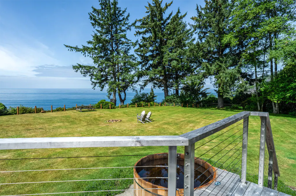 view of the ocean from the deck of one of the best winter cabins in Oregon with a cedar hot tub in yard