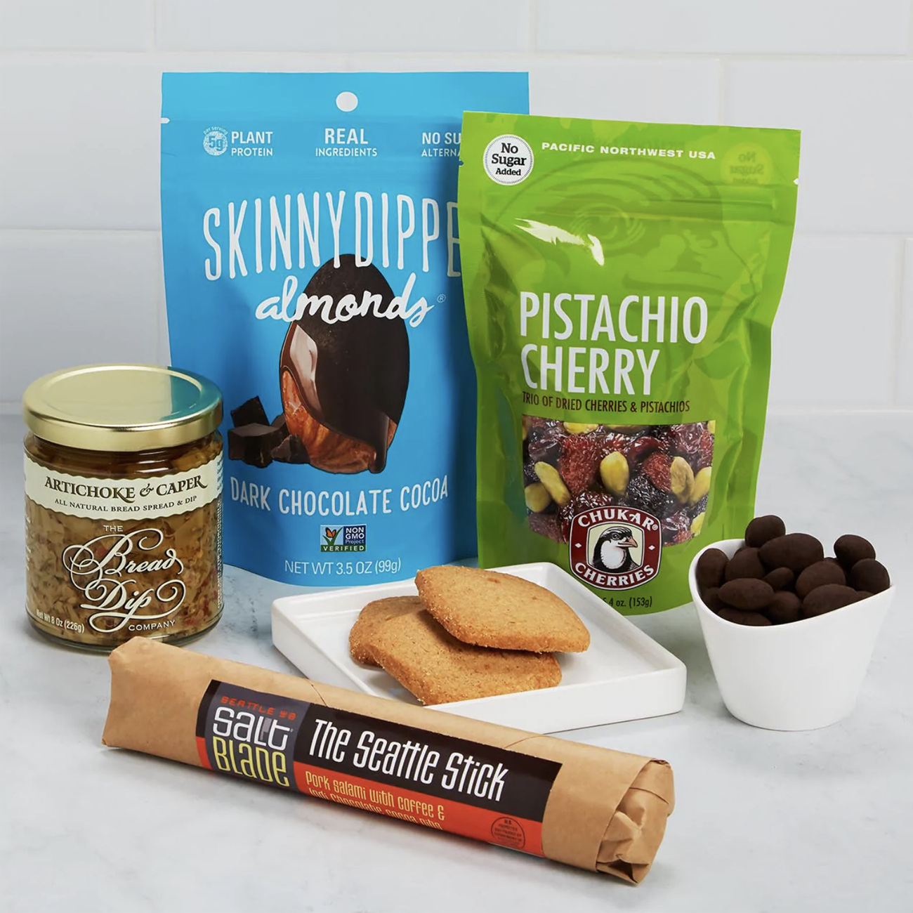 Seattle snacks: almonds, pistachio, chocolate covered cherries, salami, crackers, and artichoke spread