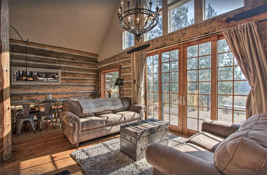 interior of a wintry cabin in Oregon with big windows and a chandelier
