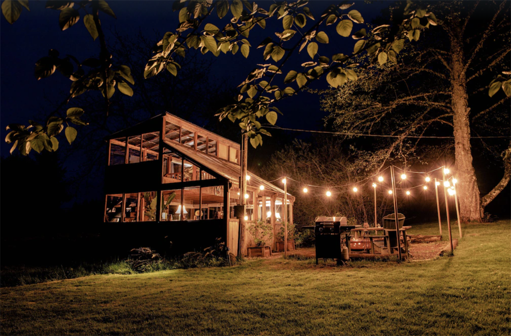 greenhouse cabin with string lights outside at night