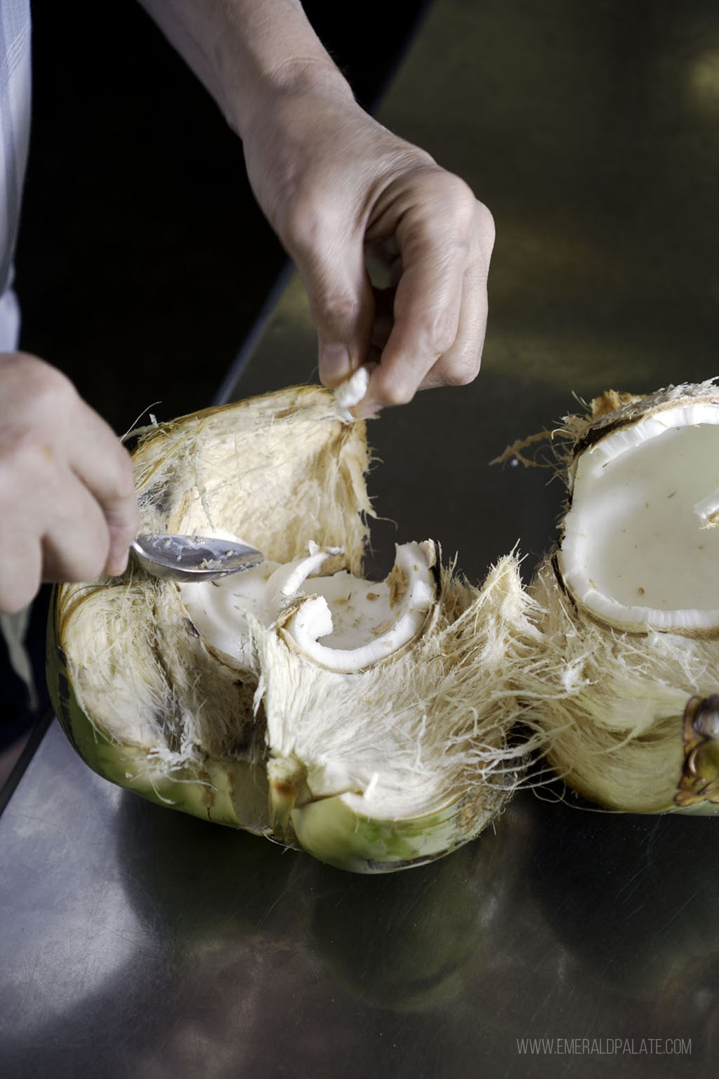 person scraping out coconut