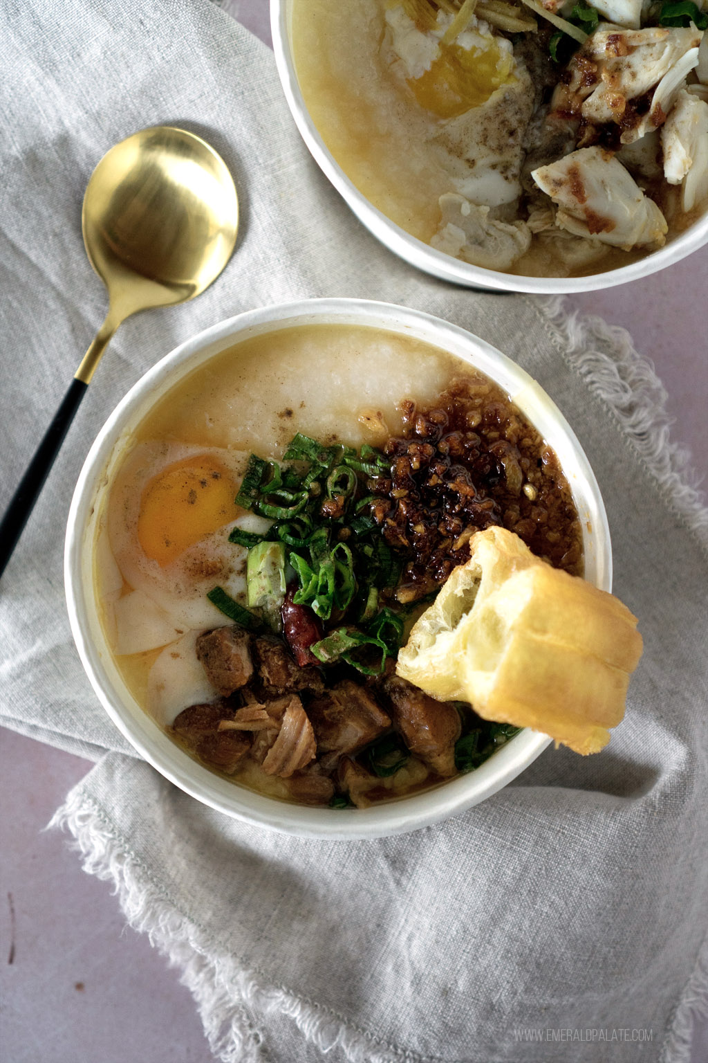 bowl of congee with pork belly and a doughnut, one of the best soup in Seattle