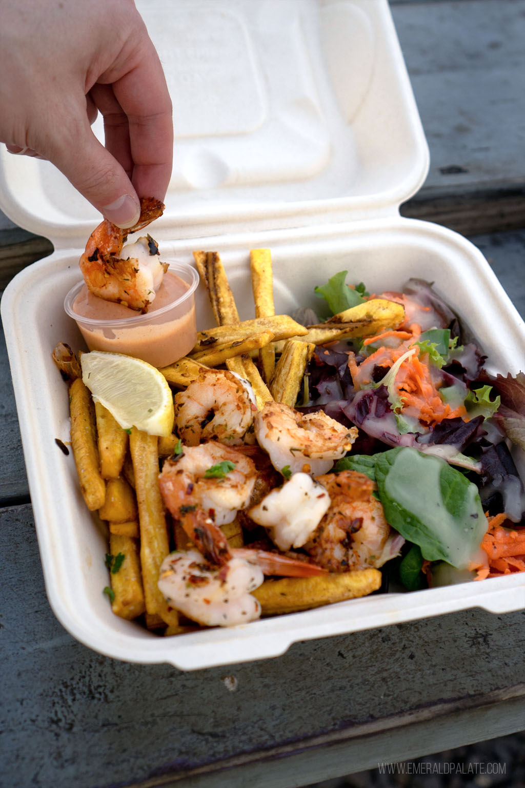 Where do the locals eat in Maui? All the places you cant miss 15 person dipping shrimp in sauce nestled in takeout container