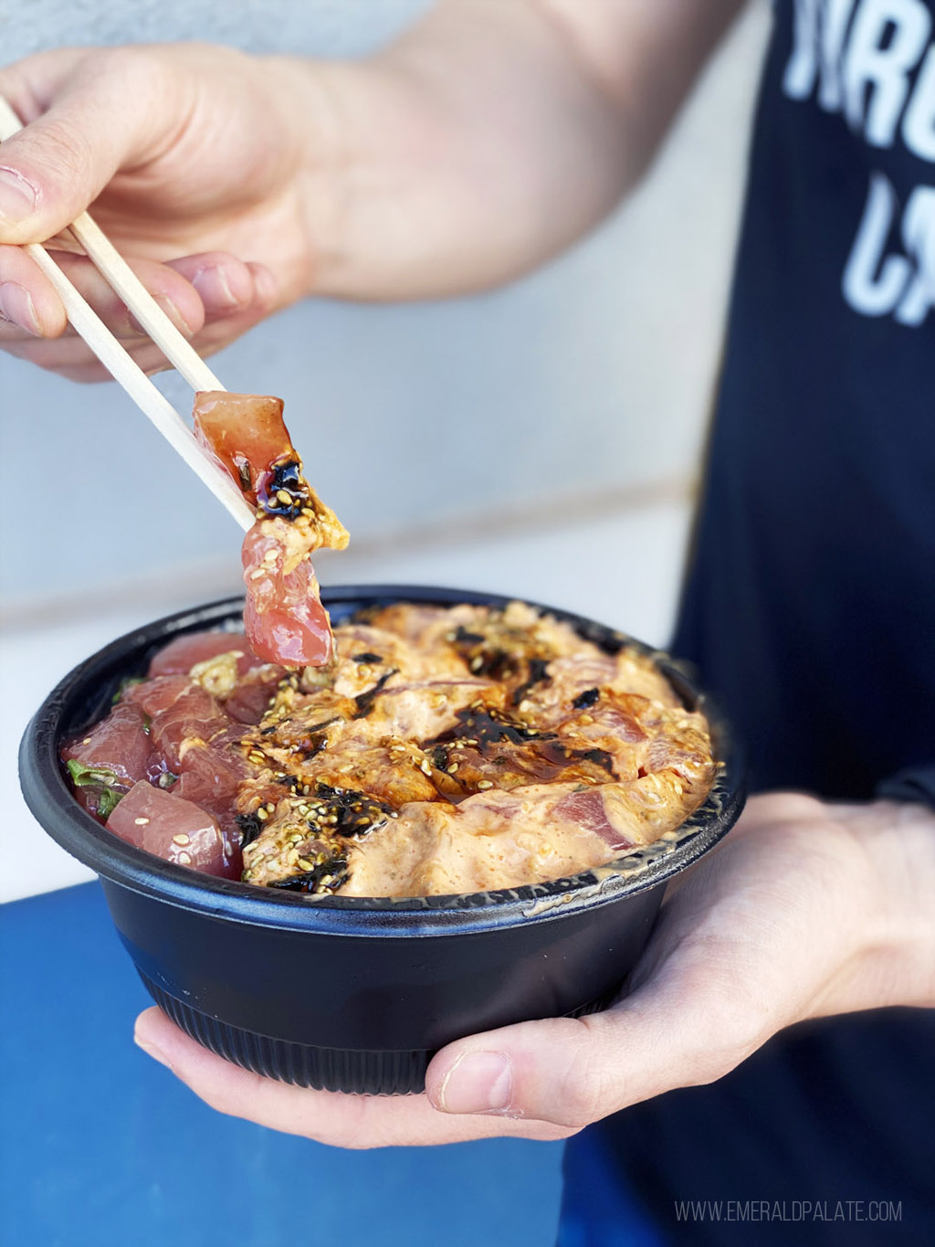 person picking up poke with chopstick from where do the locals eat in Maui