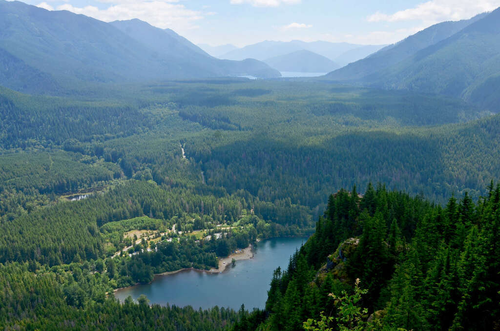View of an alpine lake and tree-covered mountains from Rattlesnake Ledge, one of the best hiking spots in Seattle