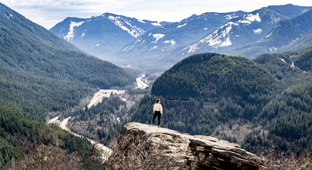 woman standing at peak of Dirty Harrys Balcony, one of the best hiking spots in Seattle