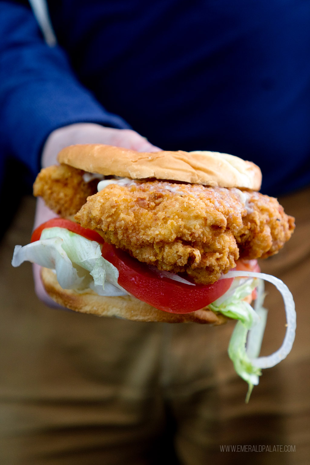 person holding a fried chicken sandwich from a Black-owned restaurant in Seattle