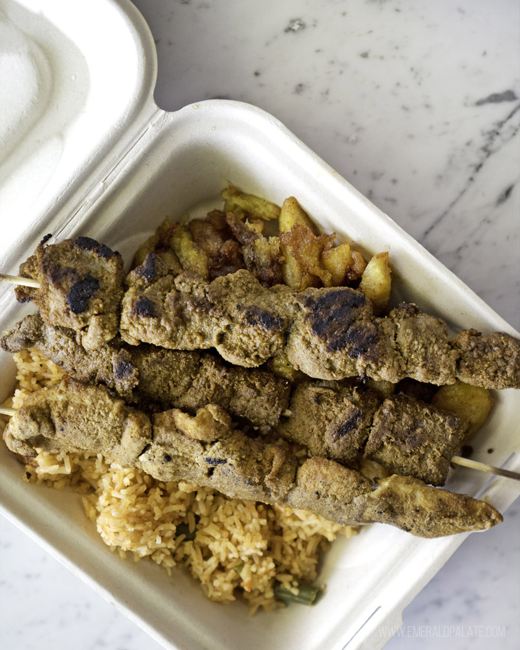 takeout container of meat skewers from a Black-owned Seattle restaurant