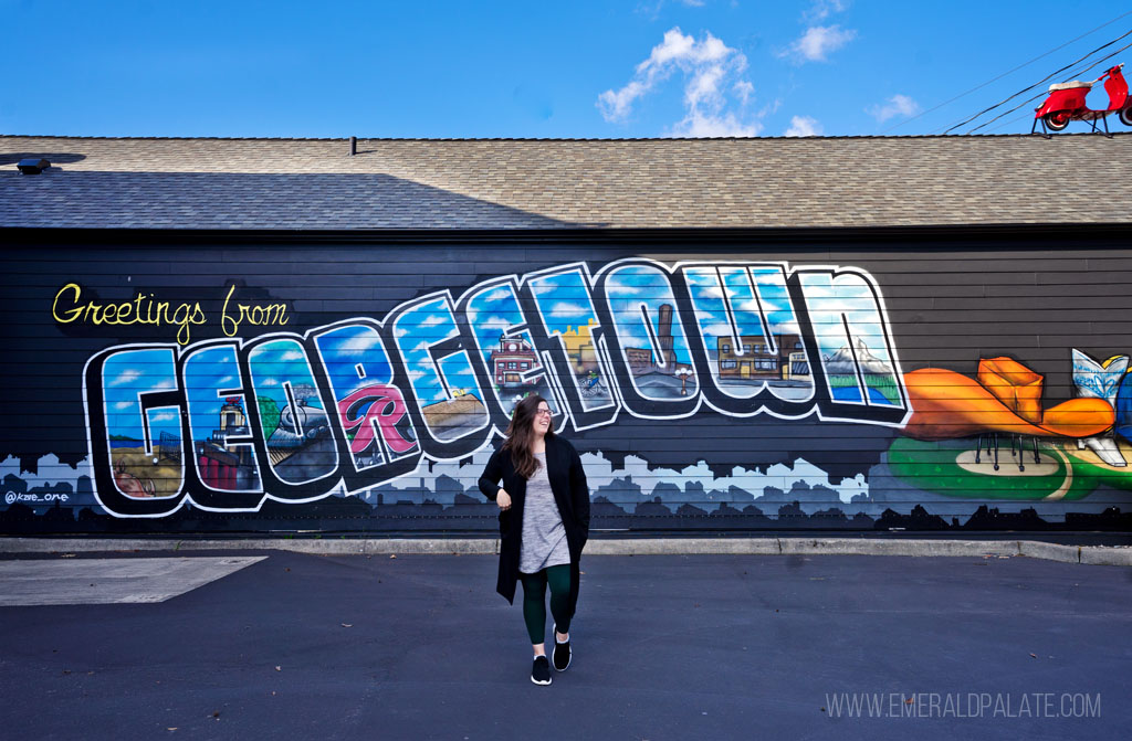 woman in front of a mural in Georgetown, a Seattle bucket list neighborhood to visit
