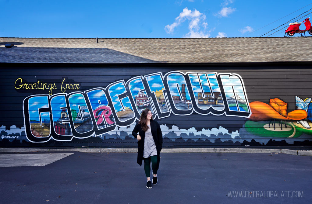 woman walking in front of a mural in the Georgetown neighborhood