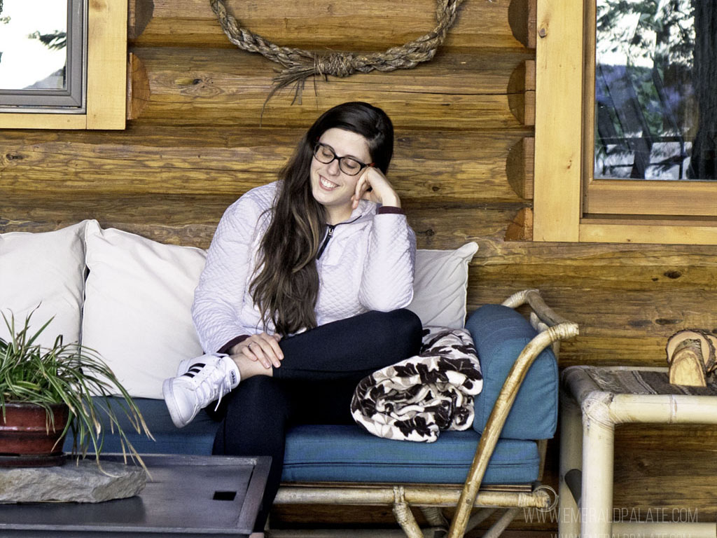 woman on the porch of one of the Washington coast cabins you should visit