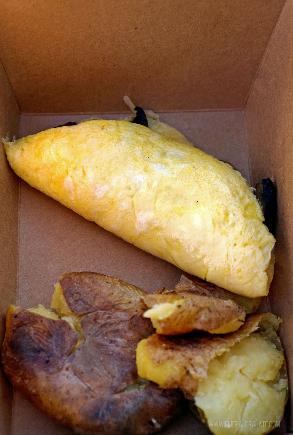 omelet and potatoes in a takeout container