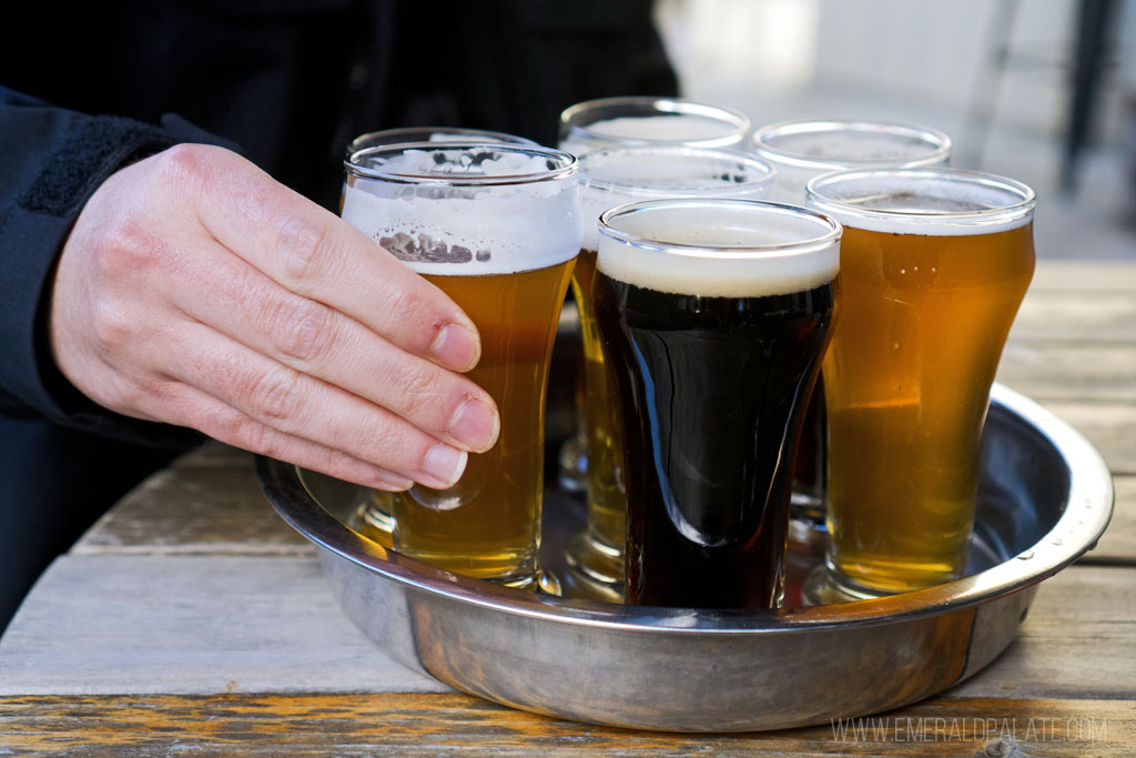 person picking up beer sampler from an Orcas Island brewery