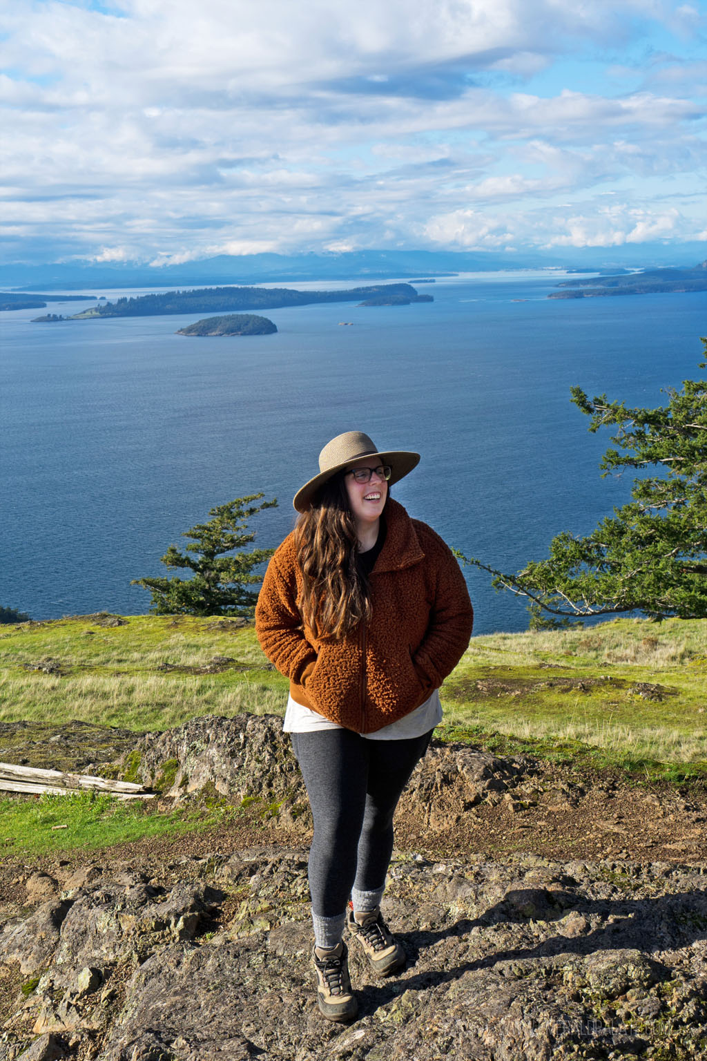 woman laughing at the top of Turtleback Mountain, a must visit during an Orcas Island day trip from Seattle
