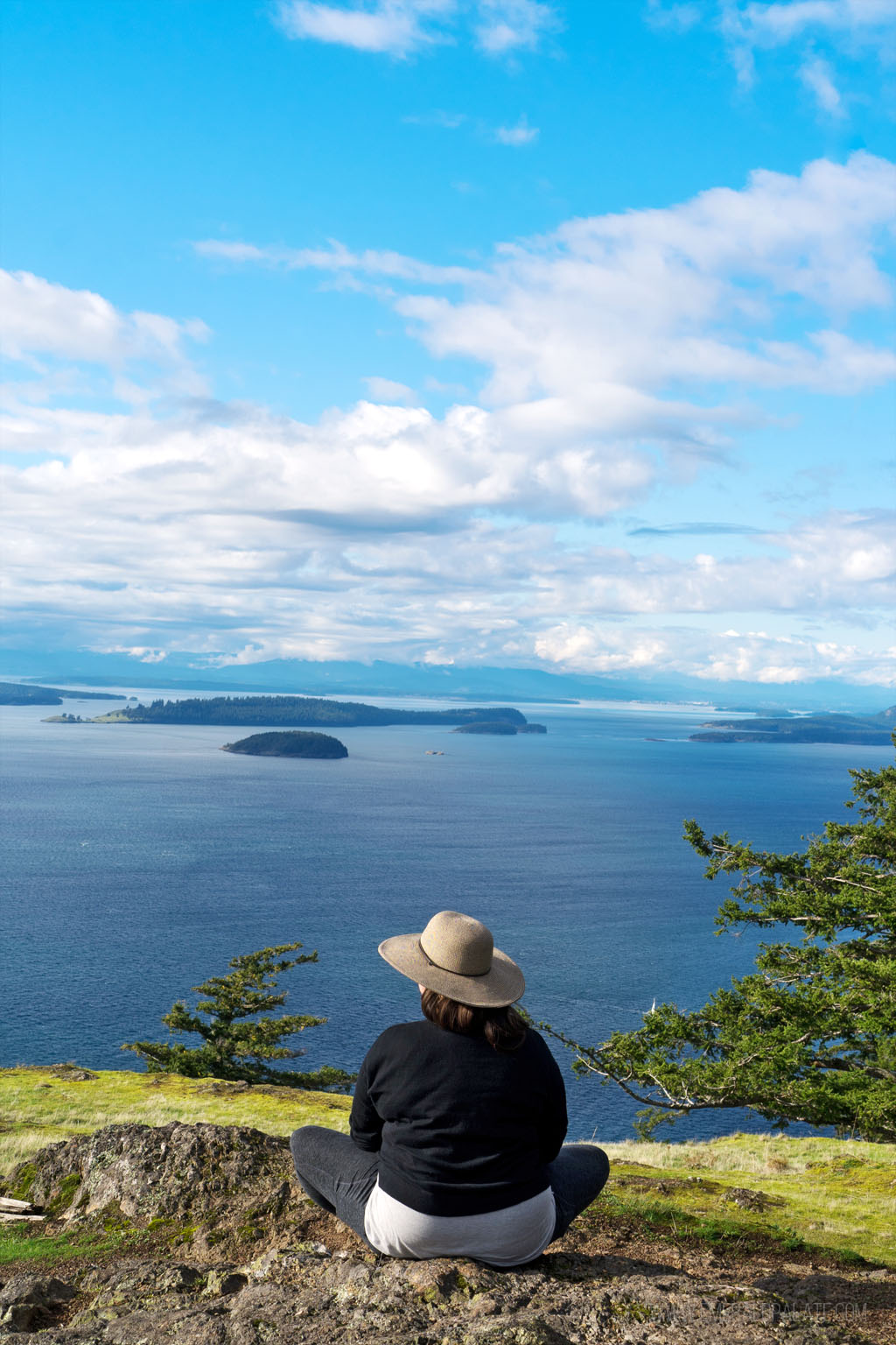 woman looking out from viewpoint onto water on the top of Turtleback Mountain a must visit on a day trip to Orcas Island from Seattle
