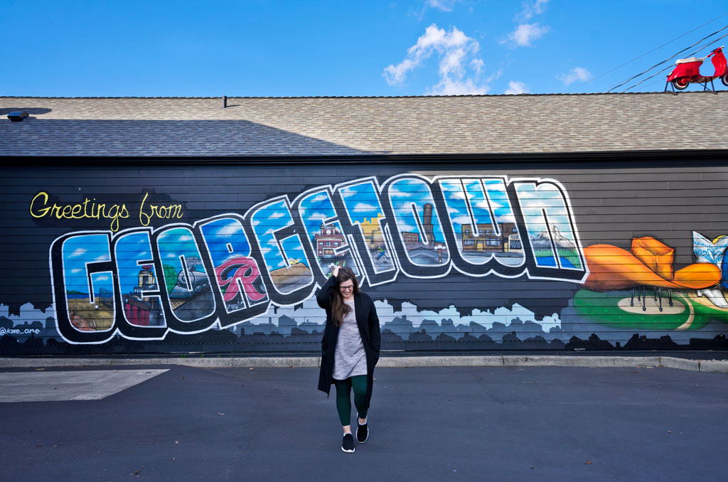 woman walking in front of a mural that says Georgetown