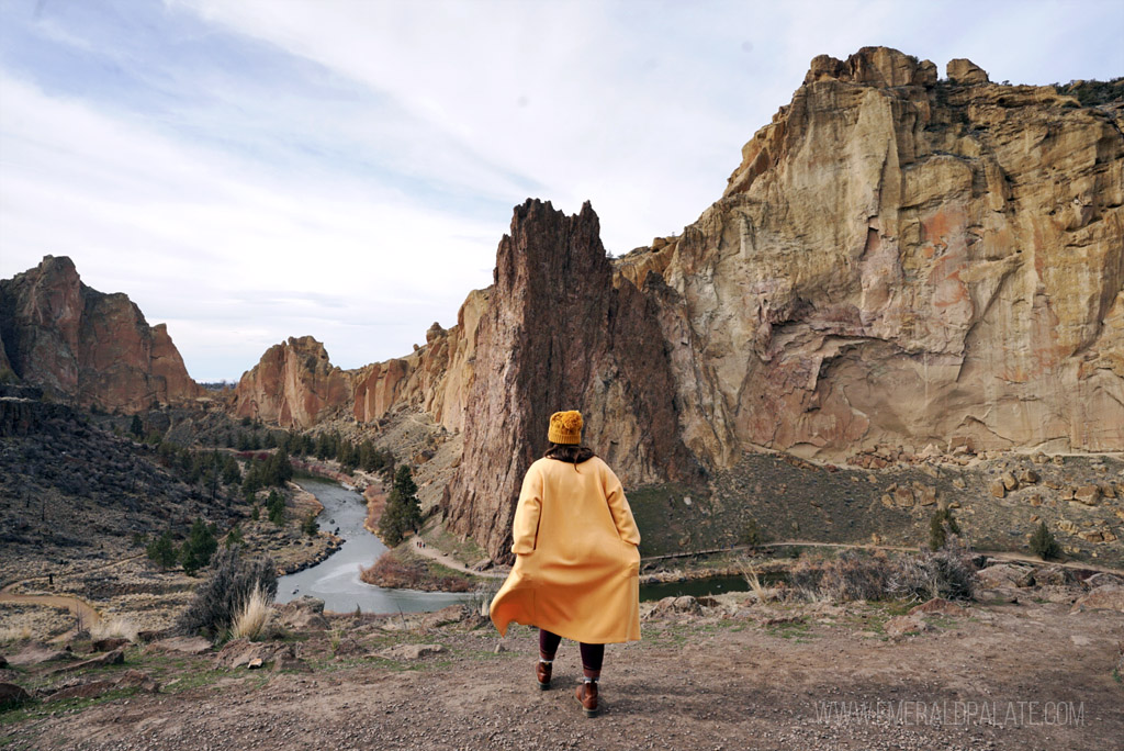 woman walking toward large rock formations in an Oregon state park