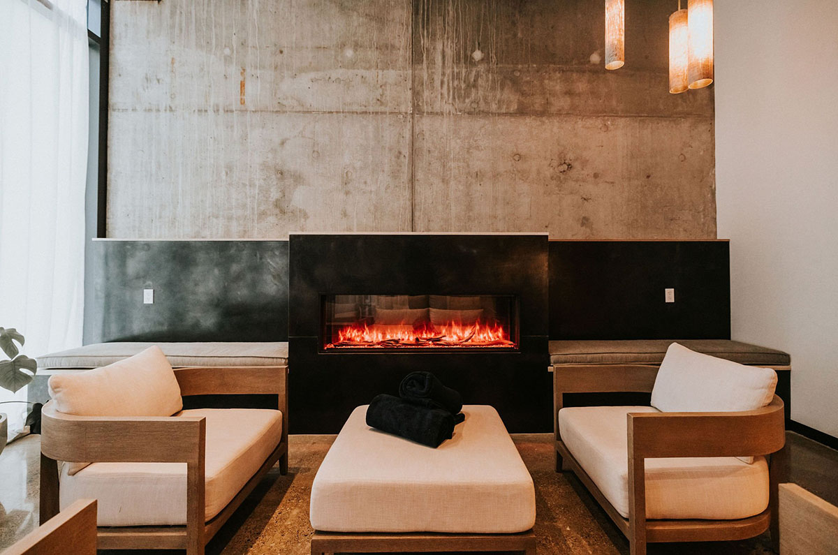Ànanya Spa Spa waiting room with a fireplace and lounge chairs