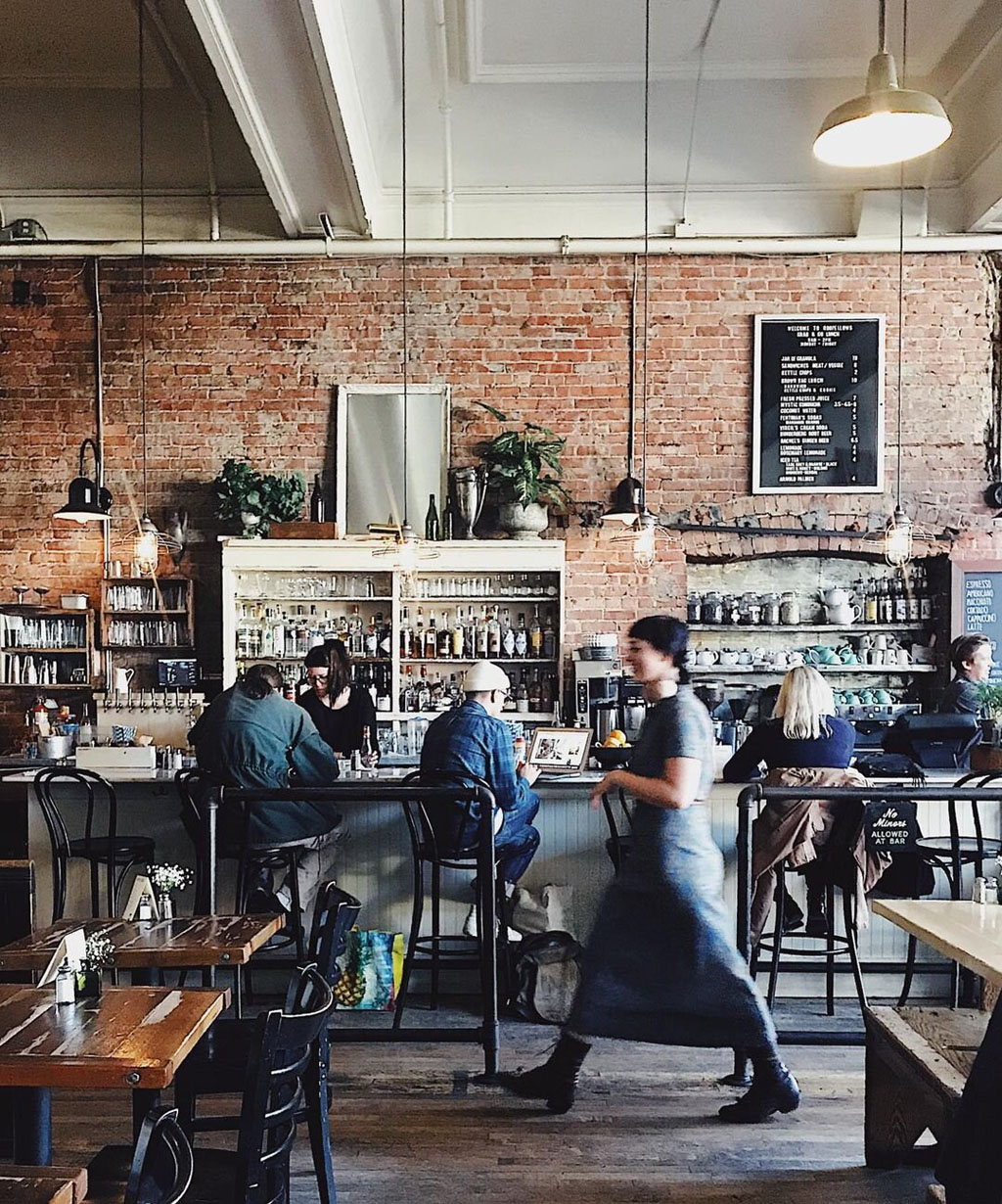 waiter blurred while they walk in a historic looking building that houses one of the most Instagram-worthy restaurants in Seattle