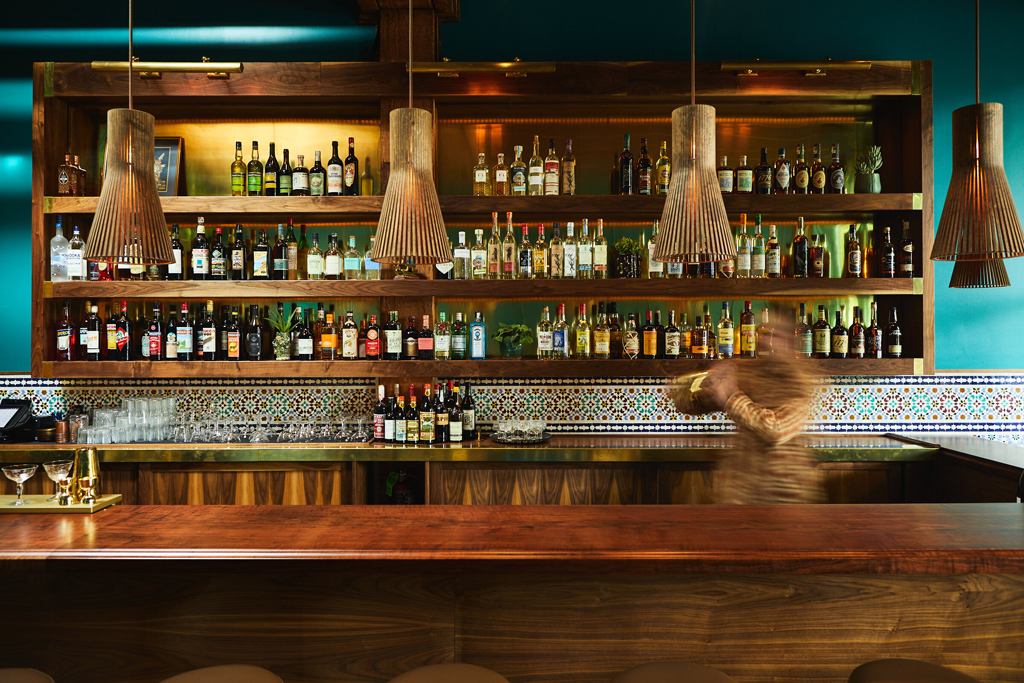 bartender using a shaker behind the bar at Rupee Bar in Seattle