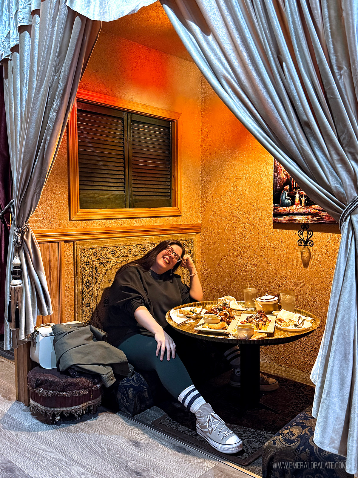 woman smiling inside an alcove booth at a Middle Eastern restaurant in Vancouver WA