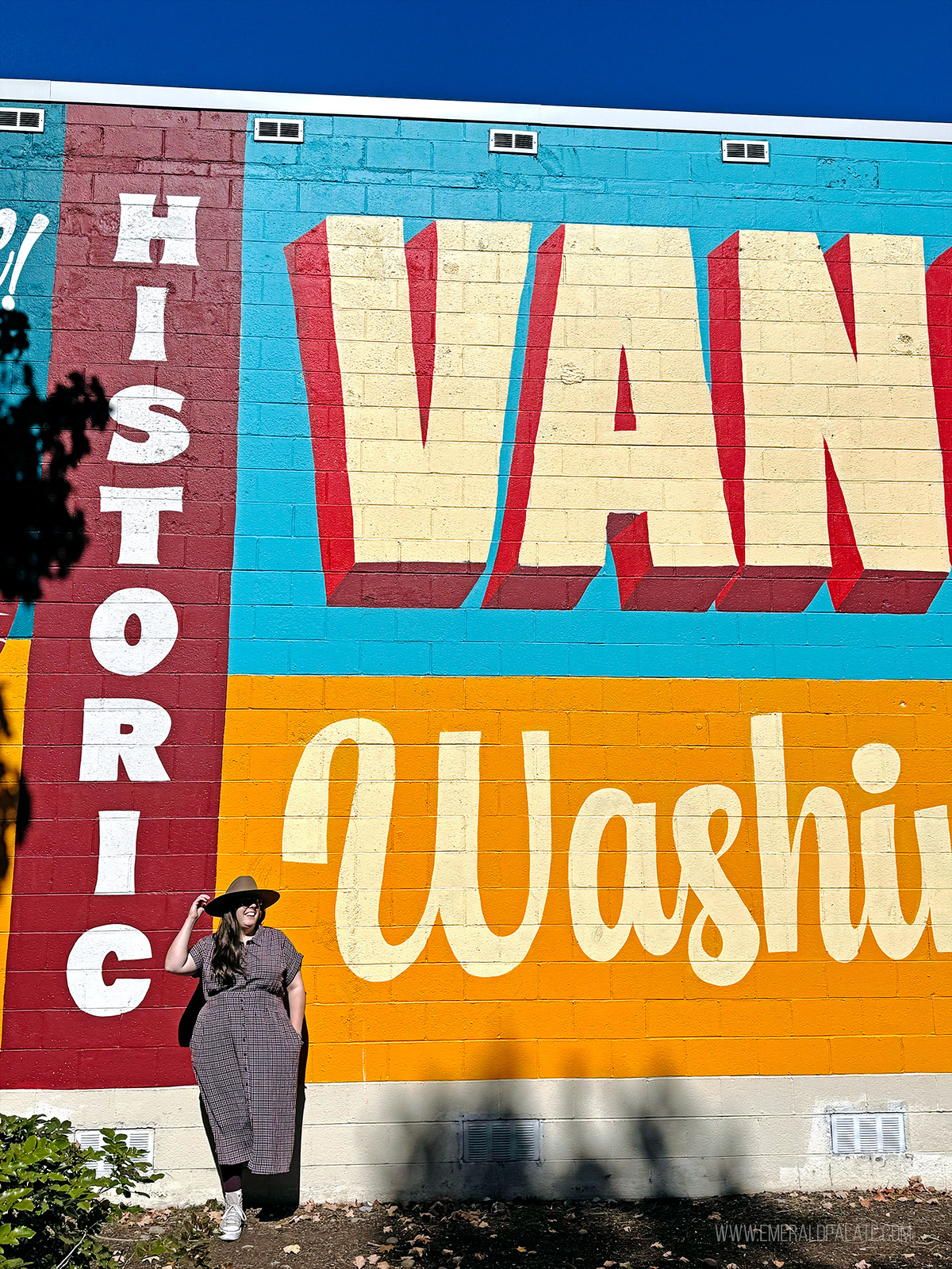 woman leaning against a mural that says historic Vancouver Washington