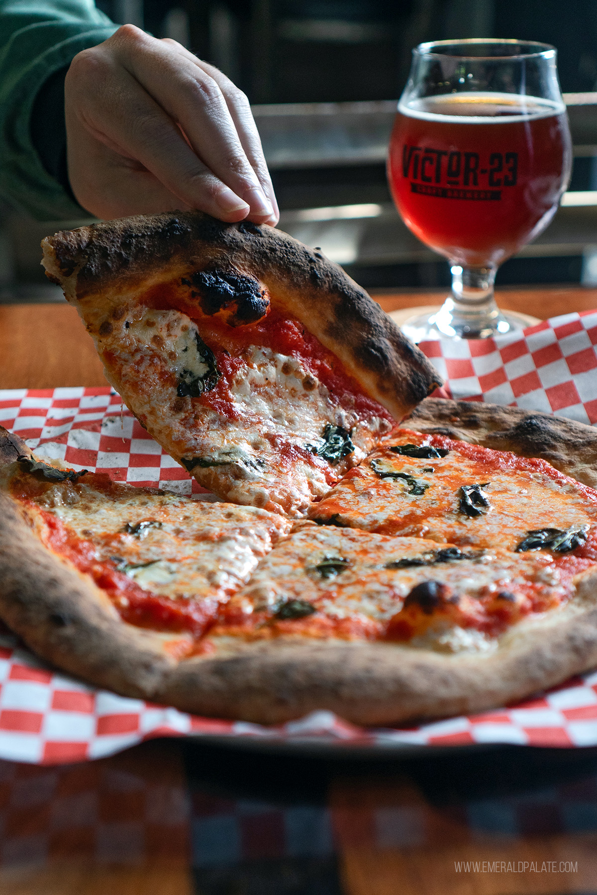 person picking up a slice of pizza at a brewery in Vancouver WA
