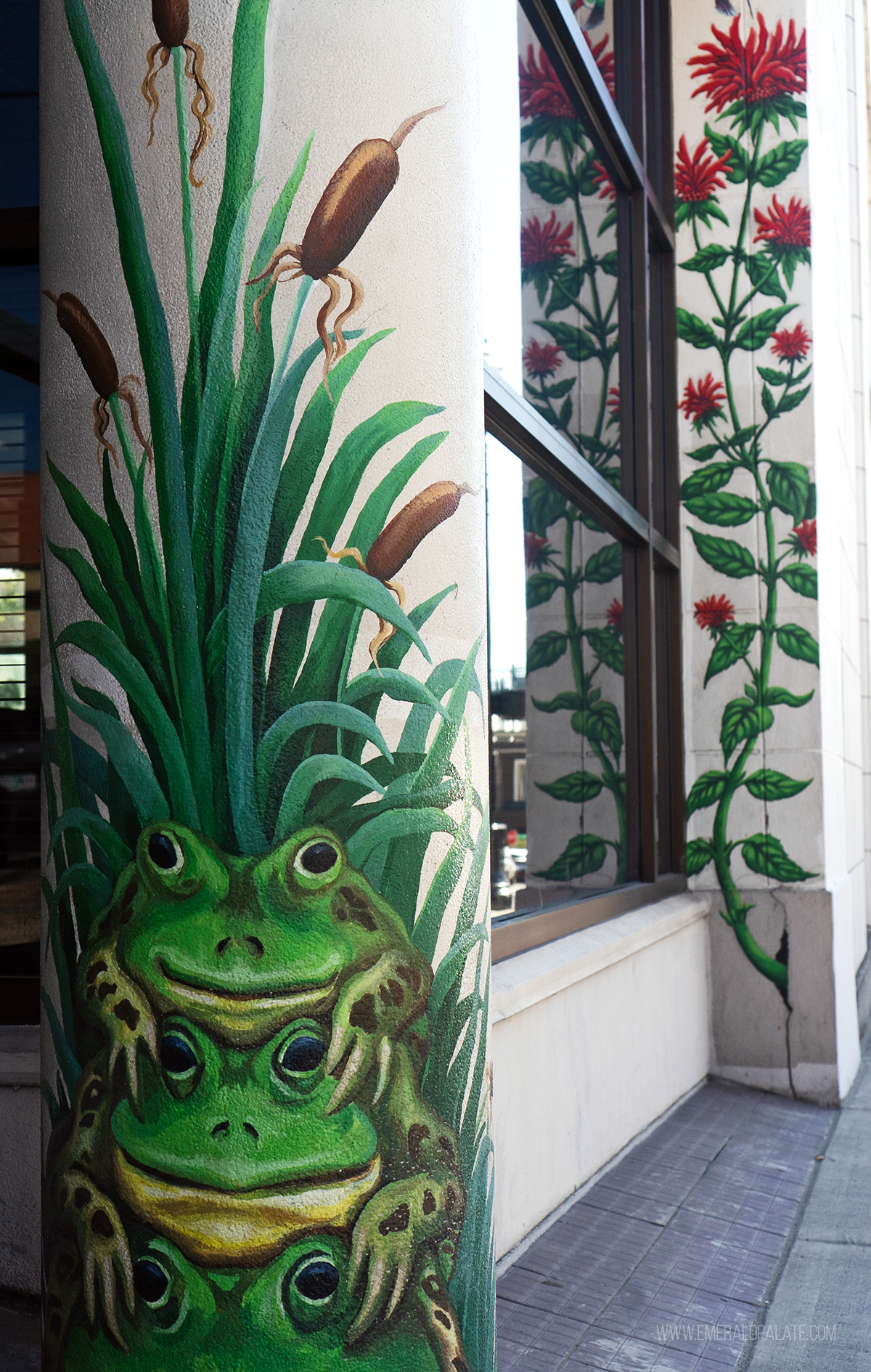 frog and plant murals on columns of a building
