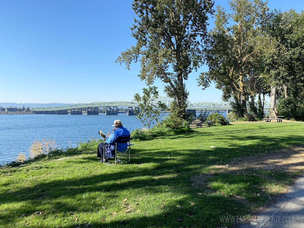 older man reading in a park overlooking the Columbia River in Vancouver, WA