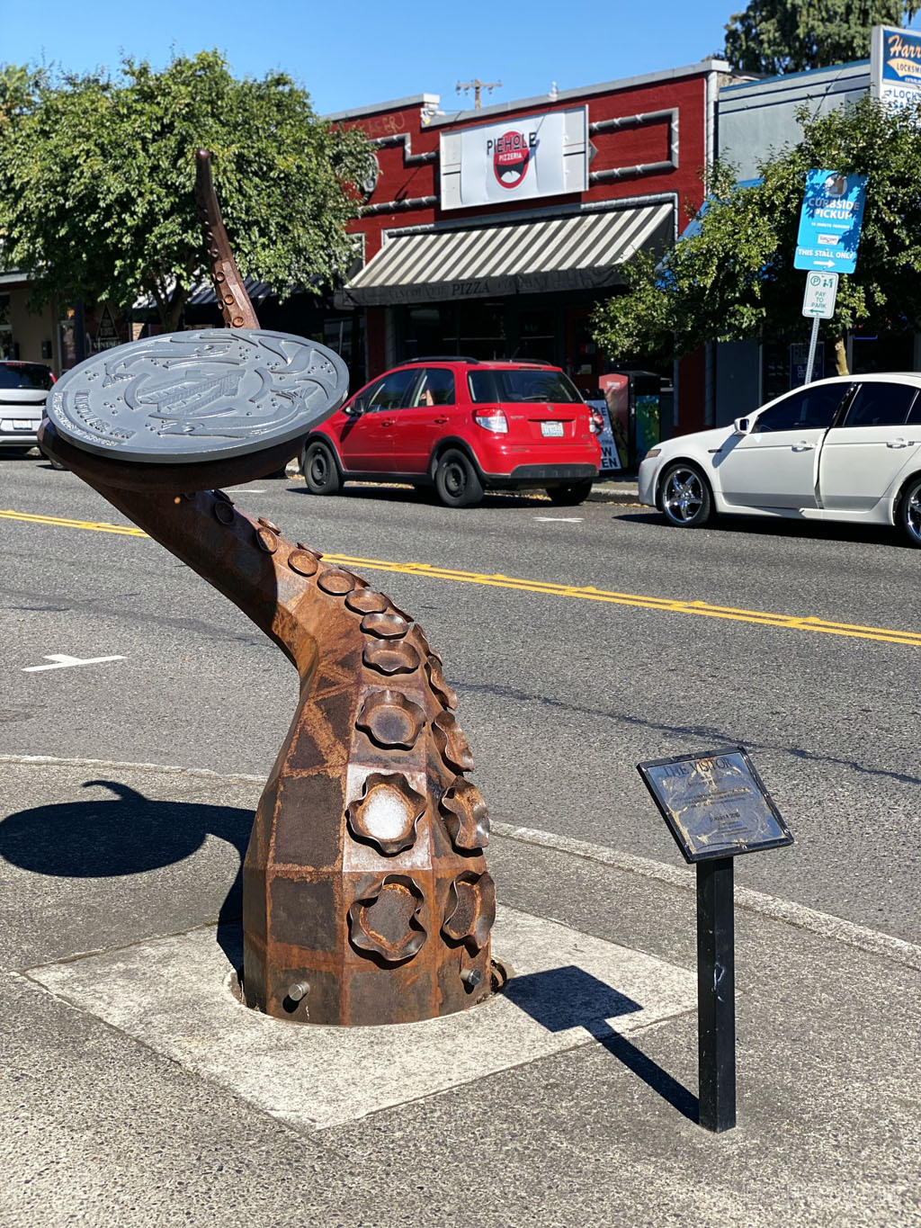octopus sculpture in Vancouver made to look like it's coming out of the sewer