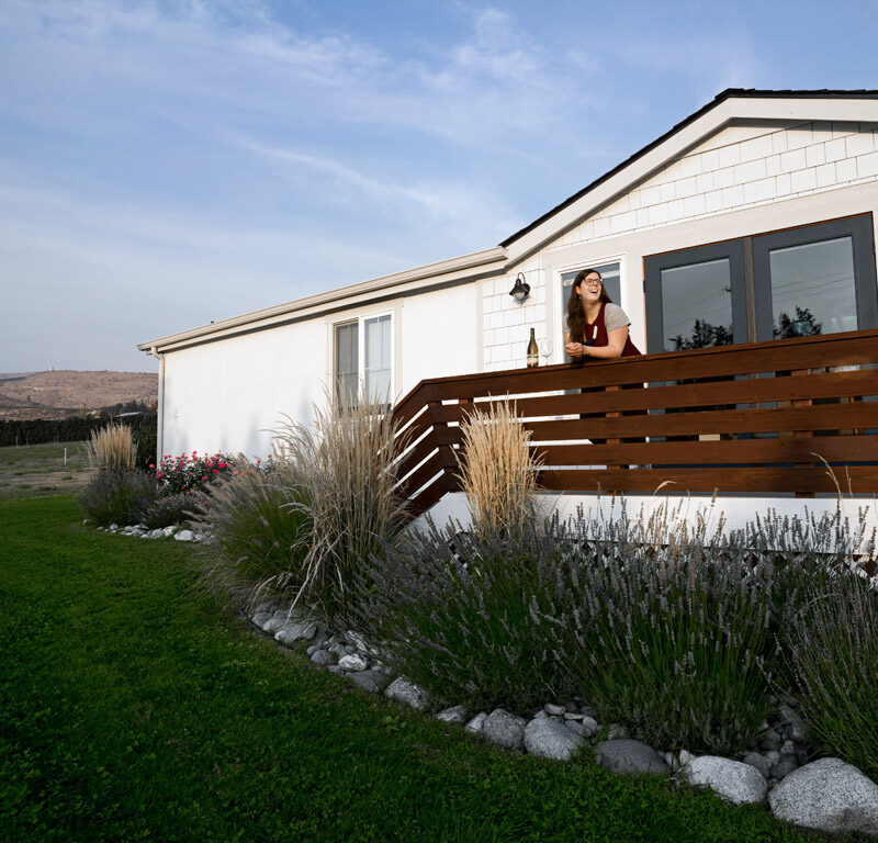 woman enjoying wine laughing on a deck at one of the best places to stay in Lake Chelan