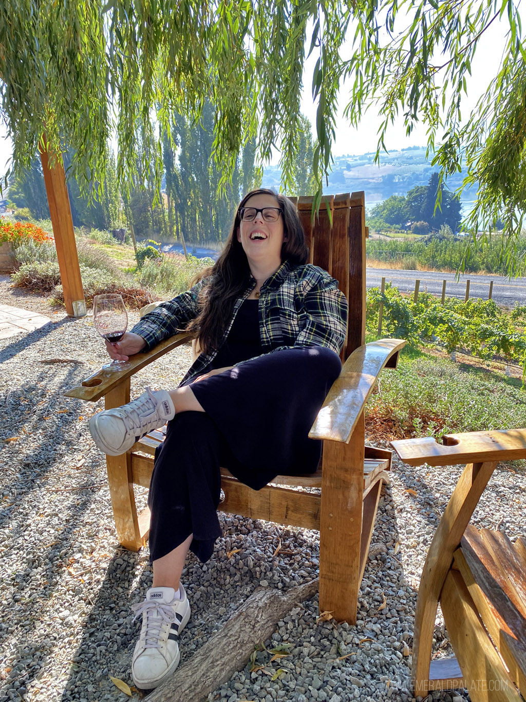 woman laughing drinking wine under a willow tree