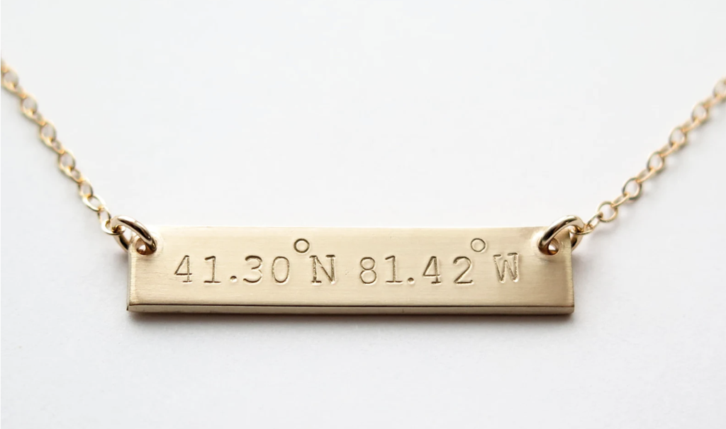 14K gold necklace with travel coordinates hand stamped on it