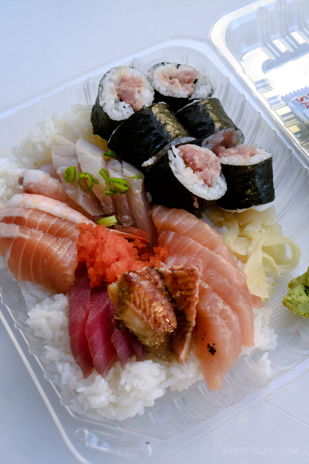 takeout container of unagi, sashimi, and a tuna roll