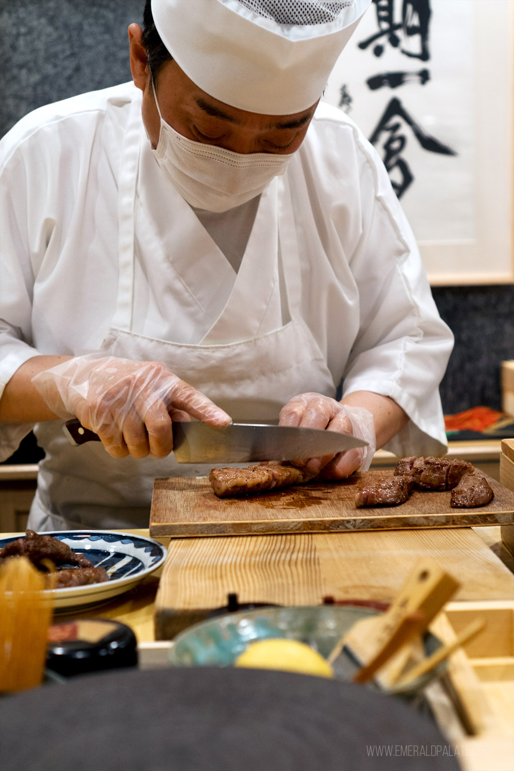 Chef Taneda chopping wagyu beef at an omakase chefs counter