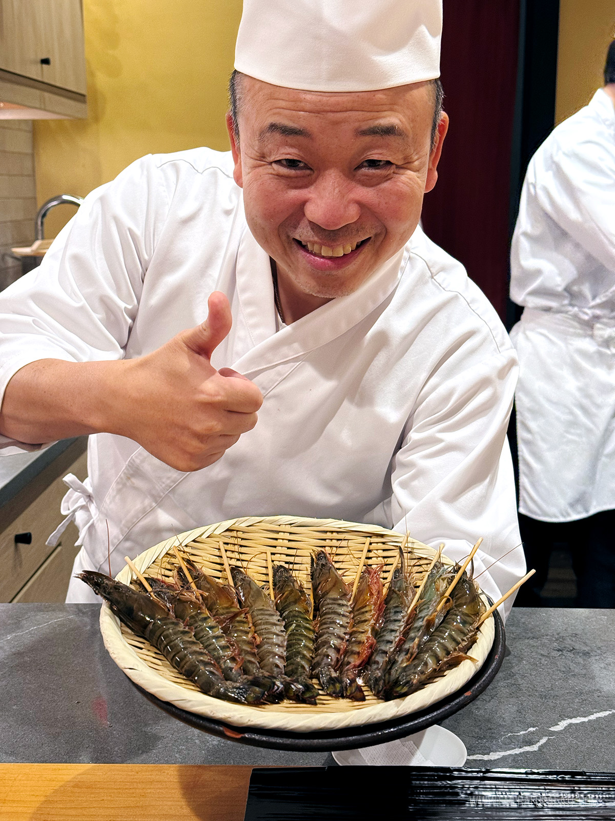 Chef Suzuki in Seattle giving a thumbs up while displaying raw spot prawn